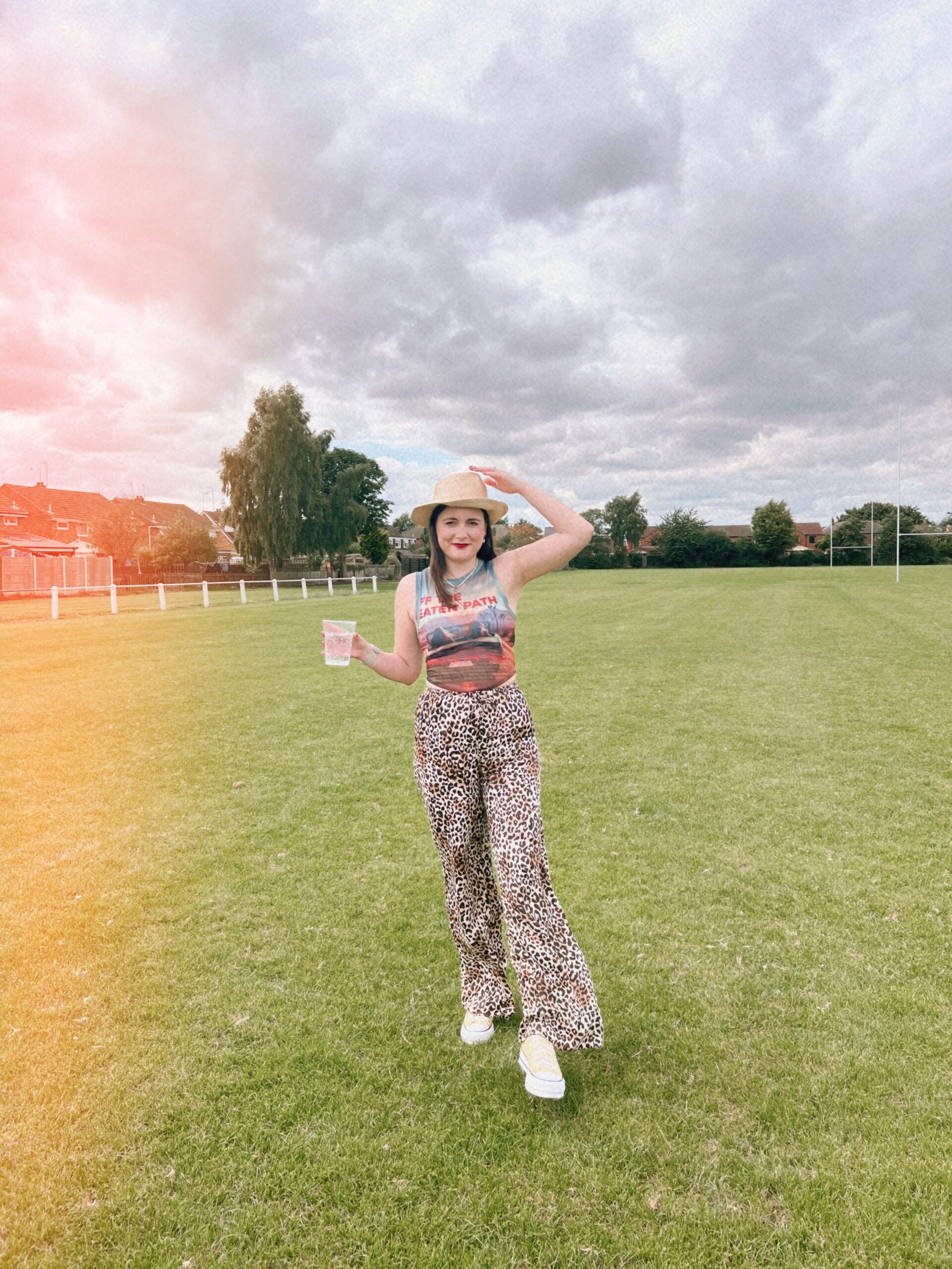 Amy, our stylish influencer, rocking a cowboy and animal print trousers in a field.